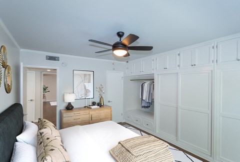 Beautifully designed bedroom with closet and cabinet space embedded into wall