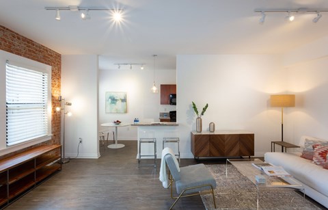 A living room with a grey chair and a white sofa.