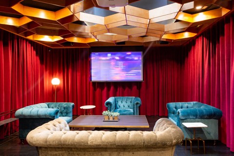 Indoor lounge space surrounded by red curtains