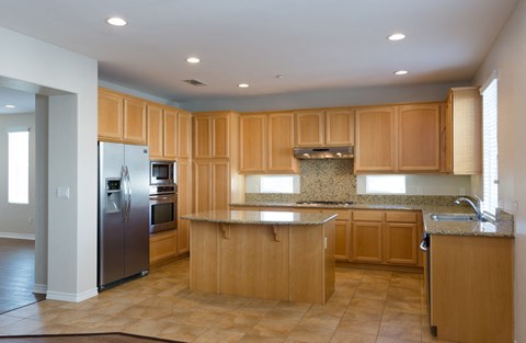 a large kitchen with wooden cabinets and stainless steel appliances