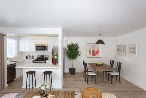 a kitchen and dining room with a wooden table and chairs