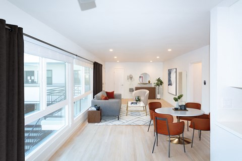 a living room with a large window and a table and chairs