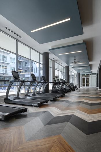 A gym with treadmills and a ceiling fan.