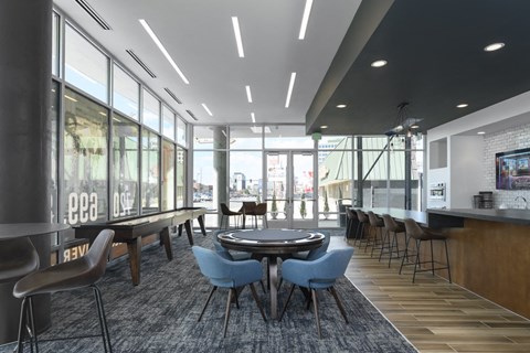 a lounge area with tables and chairs and large windows