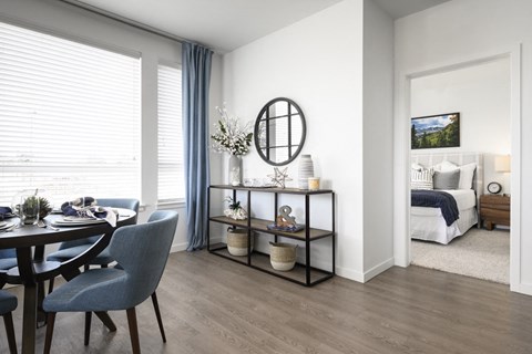 a living room and dining room with a bedroom in the background