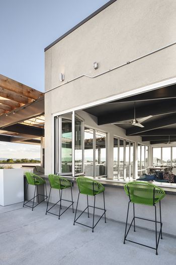 Four green chairs are placed in front of a building.