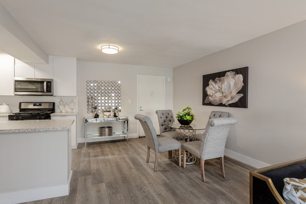 a living room and kitchen with a dining room table and chairs