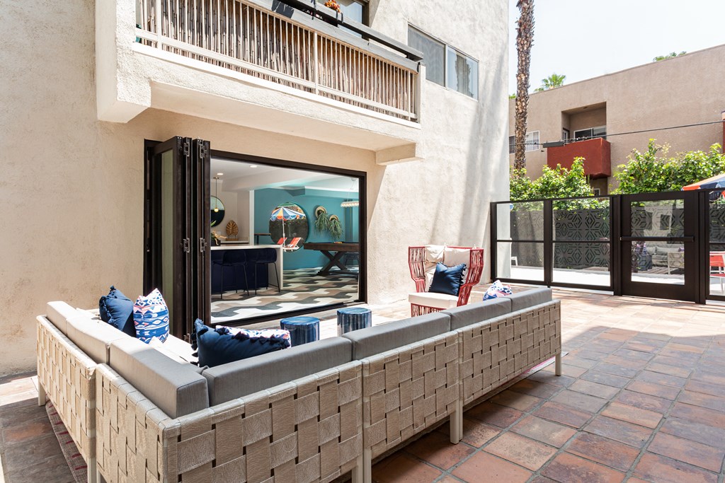 a patio with a seating area and a balcony
