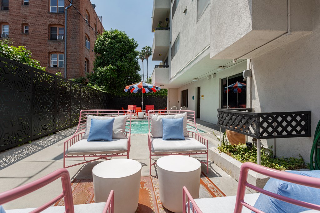 a patio with chairs and tables and a pool