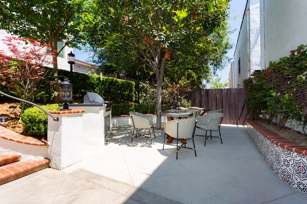 Courtyard With Colorful Patio Tables, Chairs, Umbrella and Beautiful Landscaping