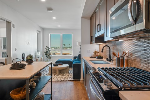 A modern kitchen with a stove top oven and a microwave above the counter.