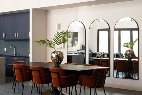 a dining room with a table and chairs and three mirrors