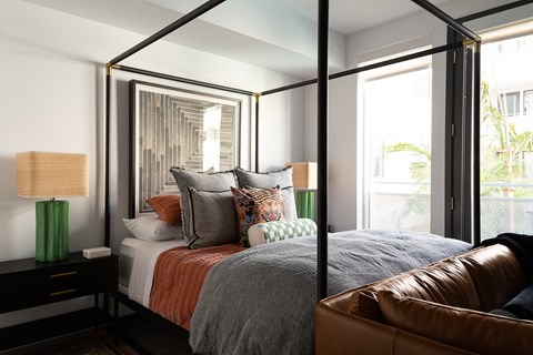 a bedroom with a large bed and a leather couch