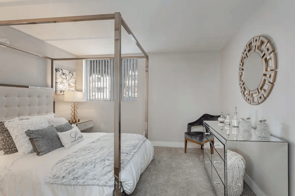 a bedroom with a large bed and a desk with a mirror