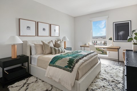 A bedroom with a large bed and a view of the city.