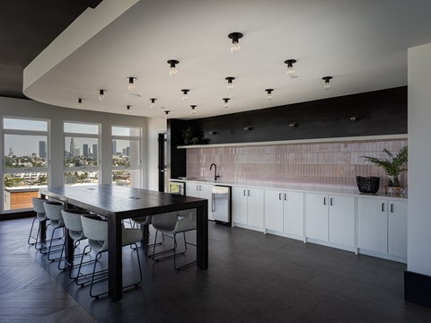 A modern kitchen with a long table and chairs.