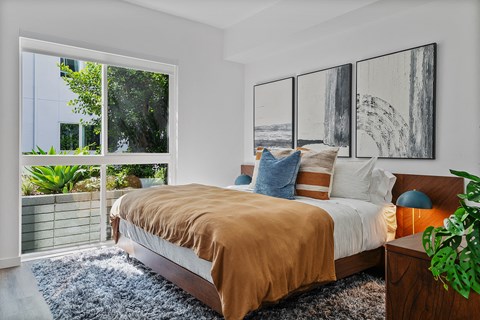 a bedroom with a bed and a large window