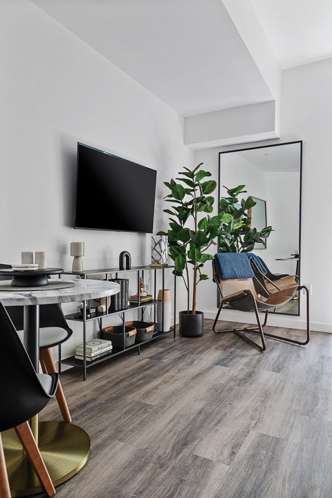 A modern living room with a black chair and a grey table.