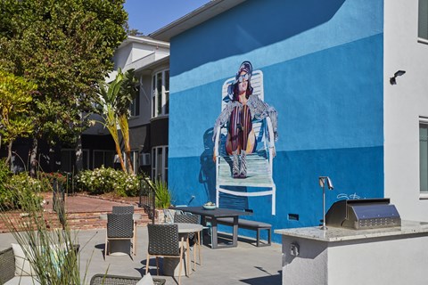 Outdoor lounge with BBQ and mural of woman relaxing on pool chair