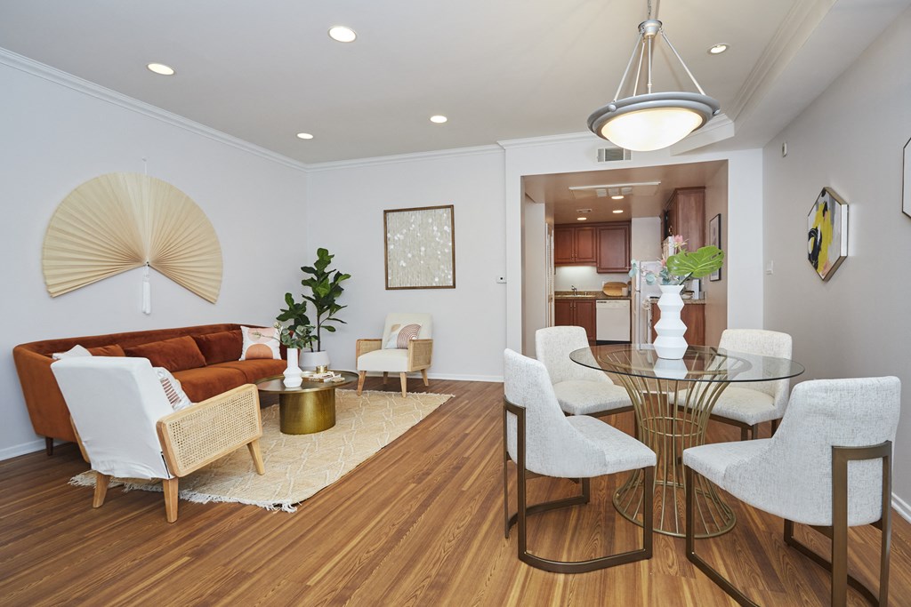 Beautifully and minimally decorated living area with white walls, wooden flooring, and tables and chairs