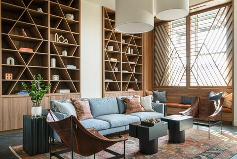 A living room with a blue couch and a wooden shelf.