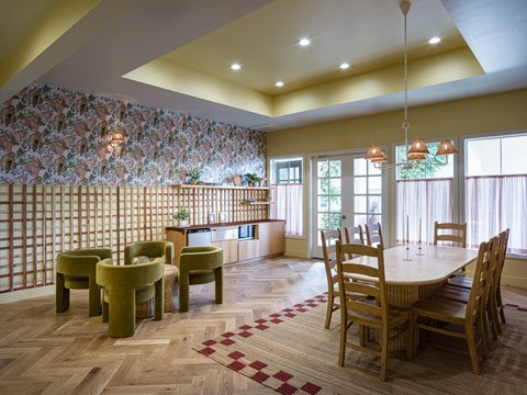 a dining room with a table and chairs and a wallpaper on the wall