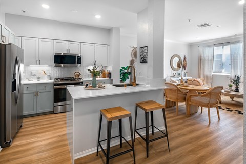 an open kitchen and living room with a large island and stools