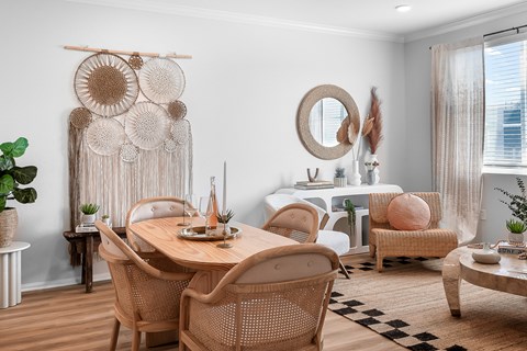 a dining room with a wooden table and rattan chairs