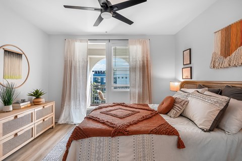 a bedroom with a bed and a ceiling fan