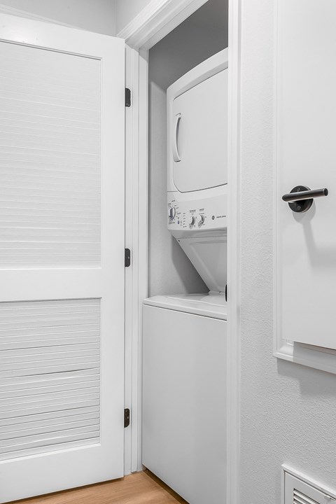 an open door to a closet with a dryer in it