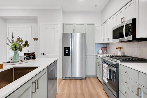 a kitchen with white cabinets and stainless steel appliances
