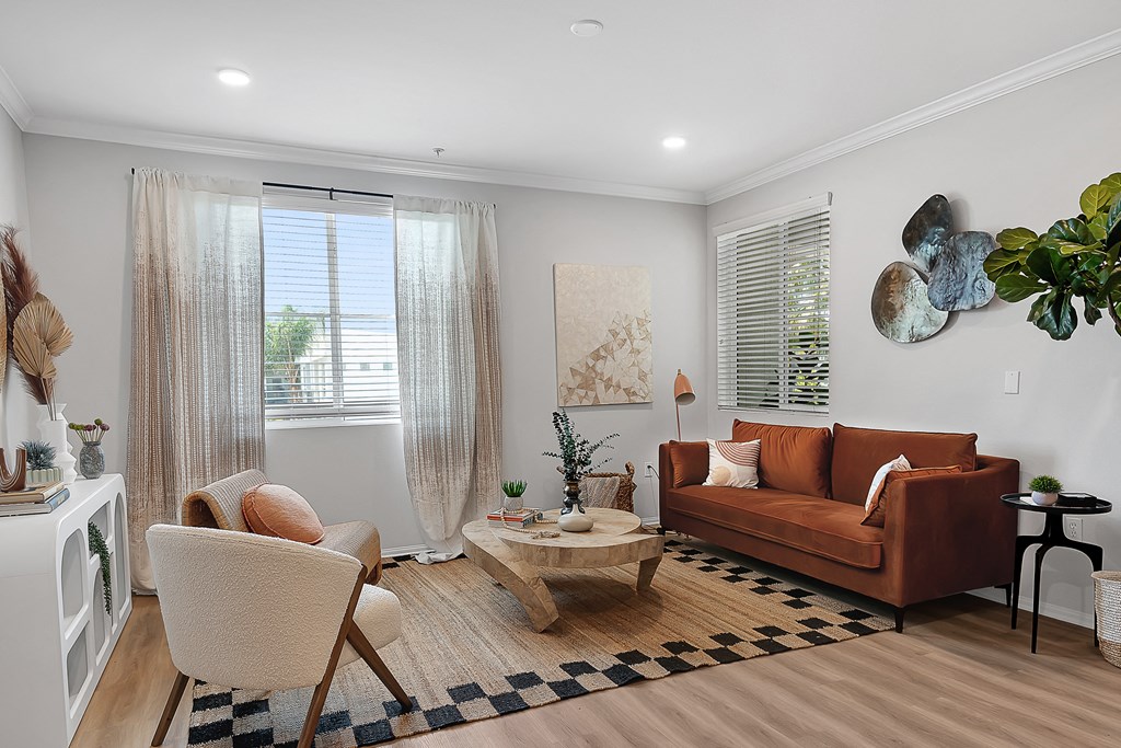 a living room with a brown couch and two white chairs