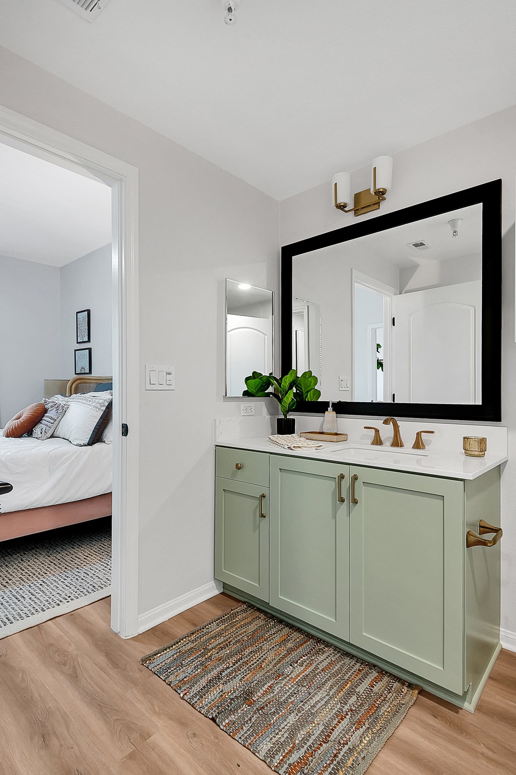a bathroom with a green vanity and a large mirror