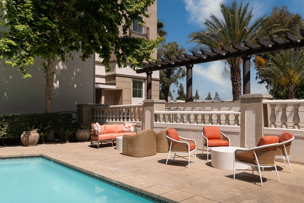 a patio with chairs and a table next to a pool