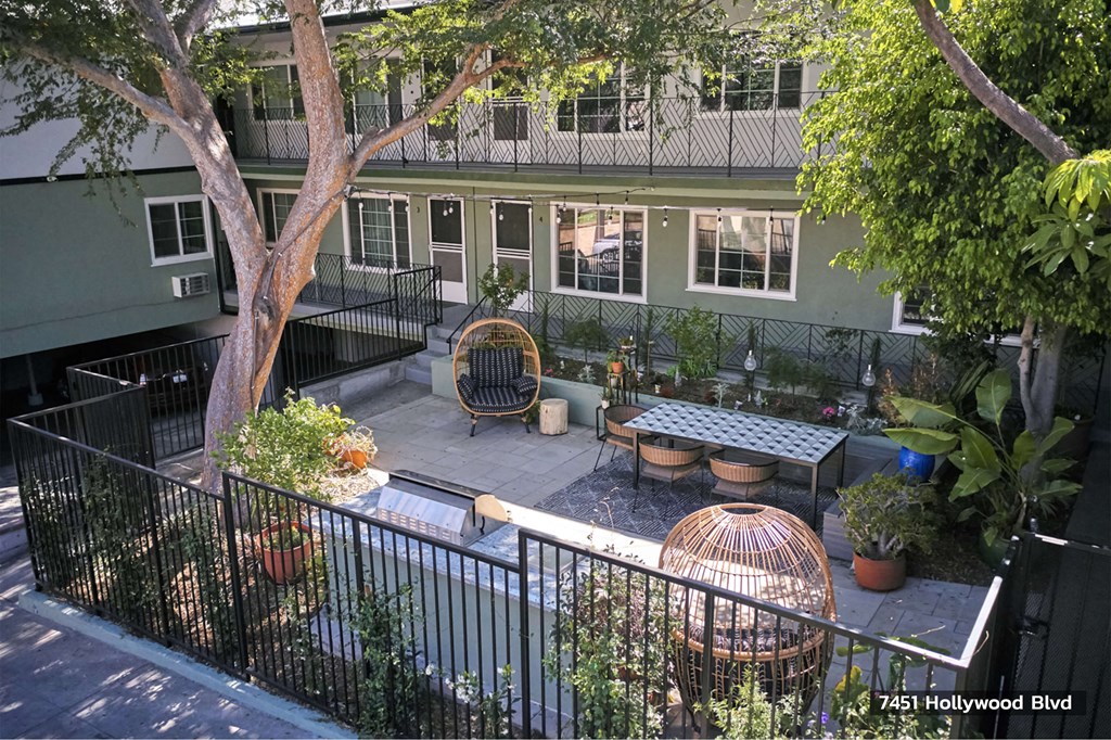 Beautiful green outdoor lounge space with seating and BBQ