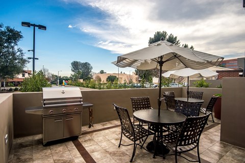 Outdoor lounge with tables and BBQ grill