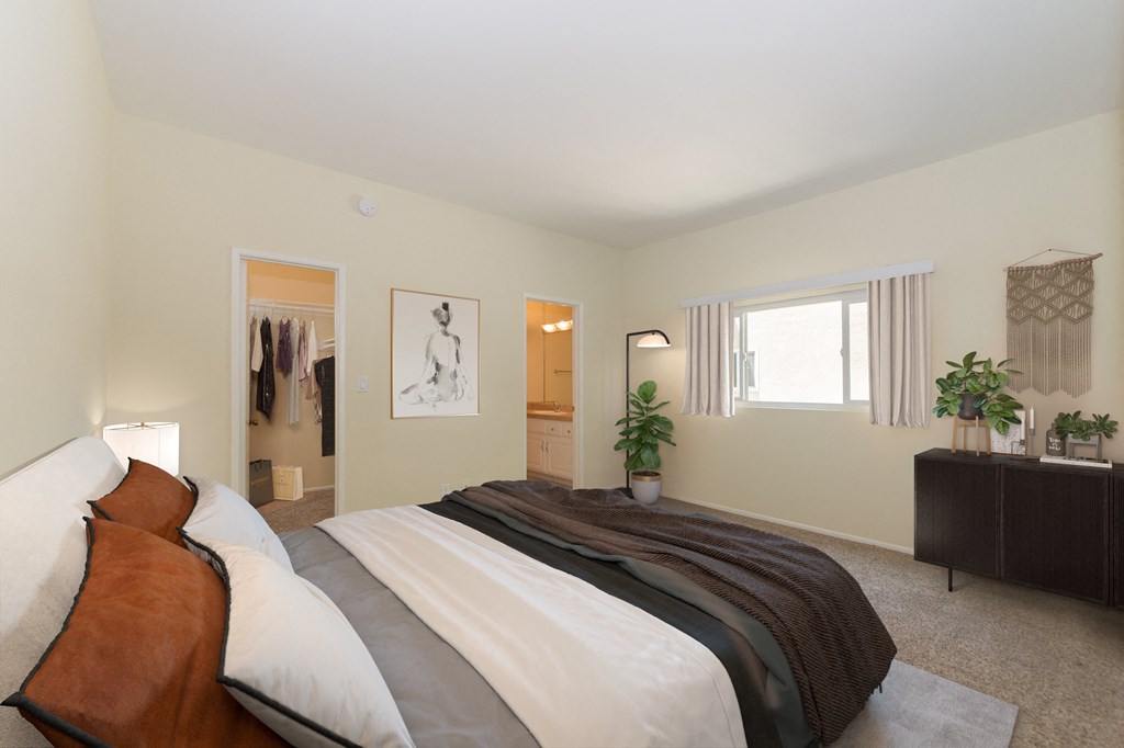 Spacious, bright bedroom with full sized bed, walk-in closet, and attached bathroom