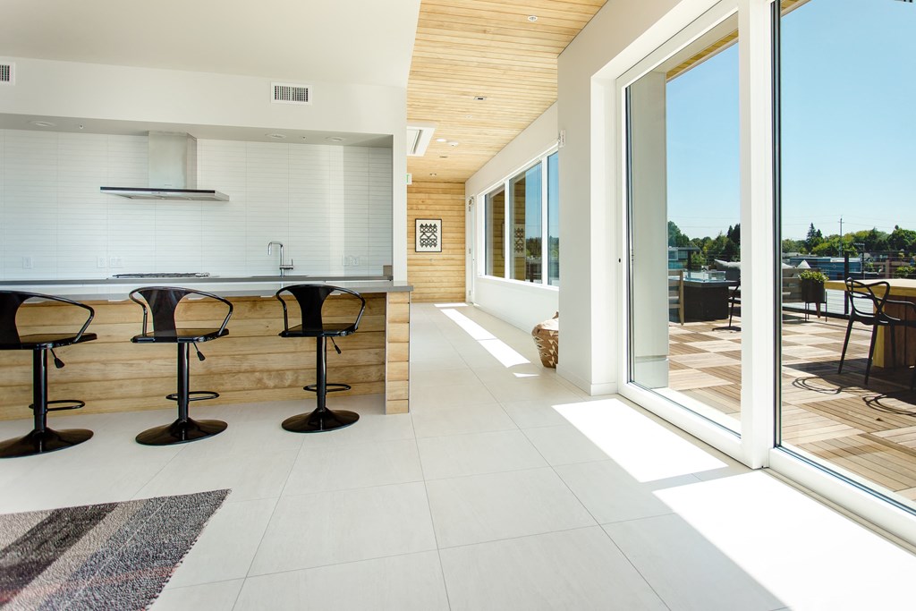 Rooftop indoor clubhouse with sliding door onto rooftop patio