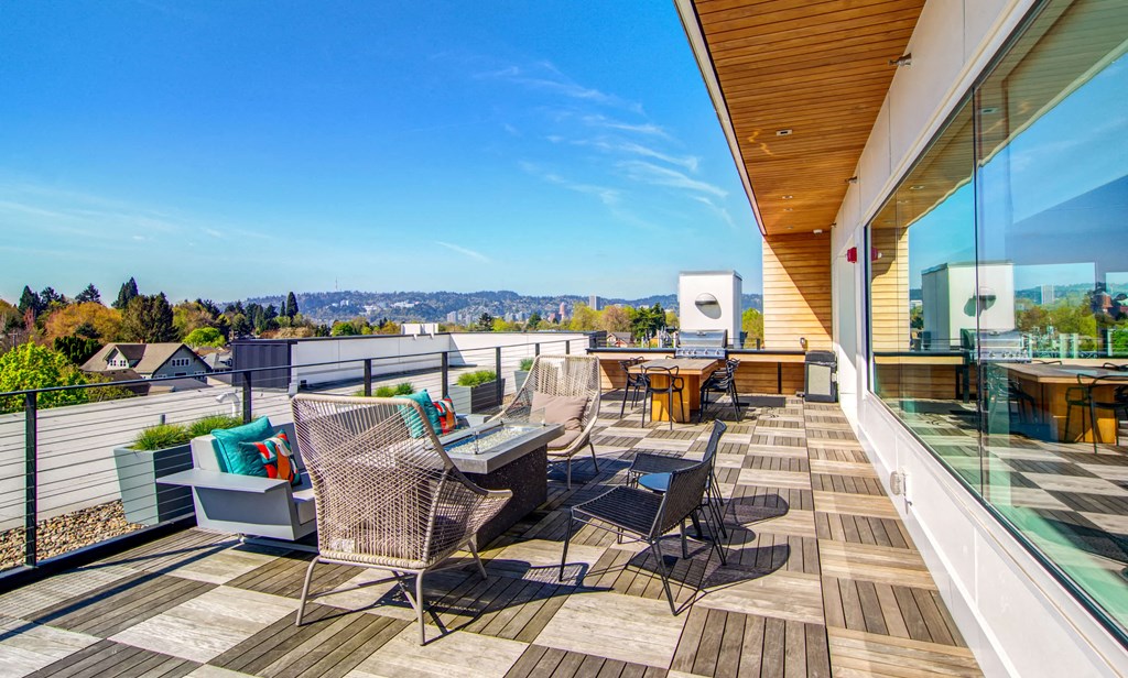 Rooftop hangout spaces with chairs, tables, and a BBQ