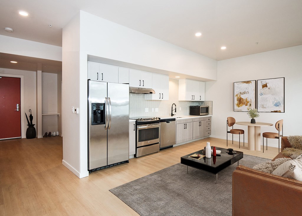a kitchen and living room with stainless steel appliances