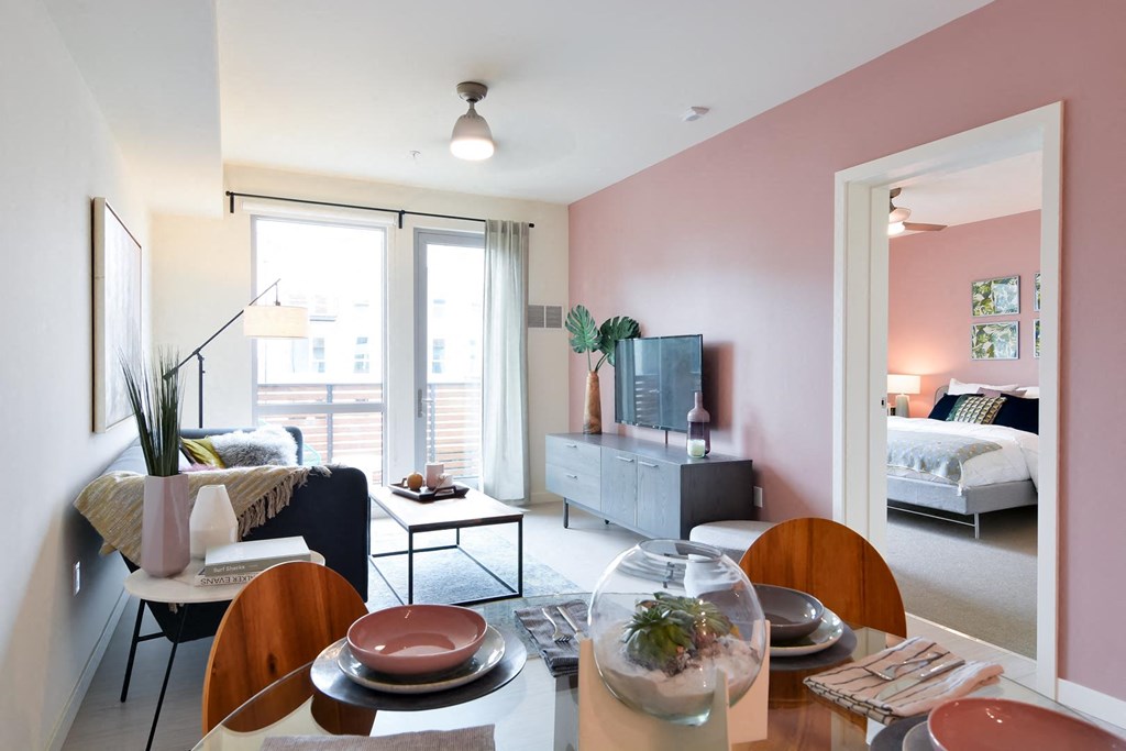Living area with door onto patio and view into bedroom
