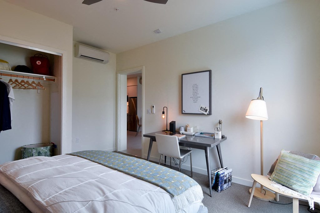 Bedroom with full bed, desk, and open closet space