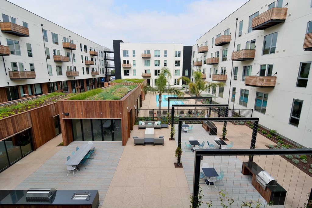 Outdoor courtyard with pool, BBQ grill, and lounge spaces