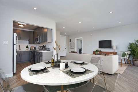 a living room and kitchen with a white table and chairs