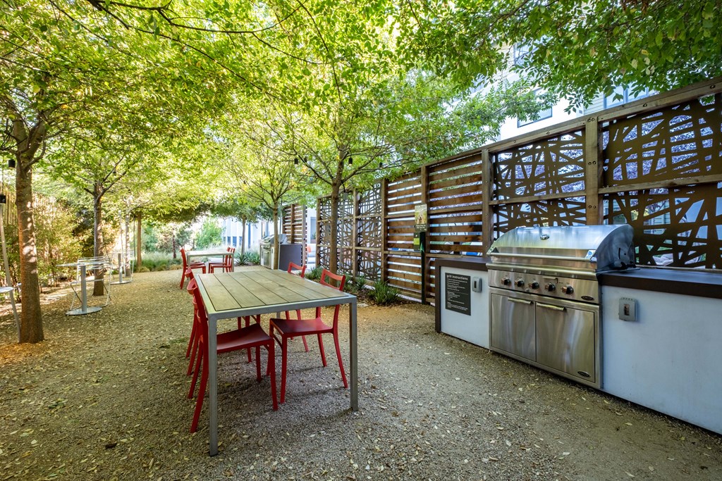 Garden grill area and table under canopy of trees