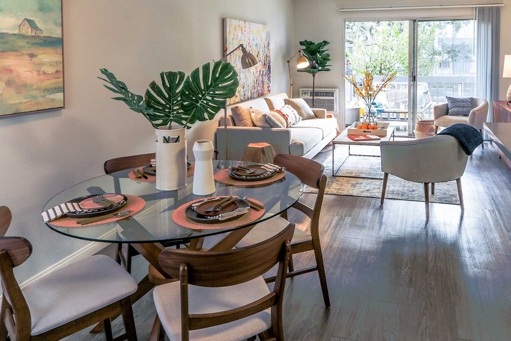 Dining Room with Wood-Inspired Flooring Connecting into the Living Room and Kitchen