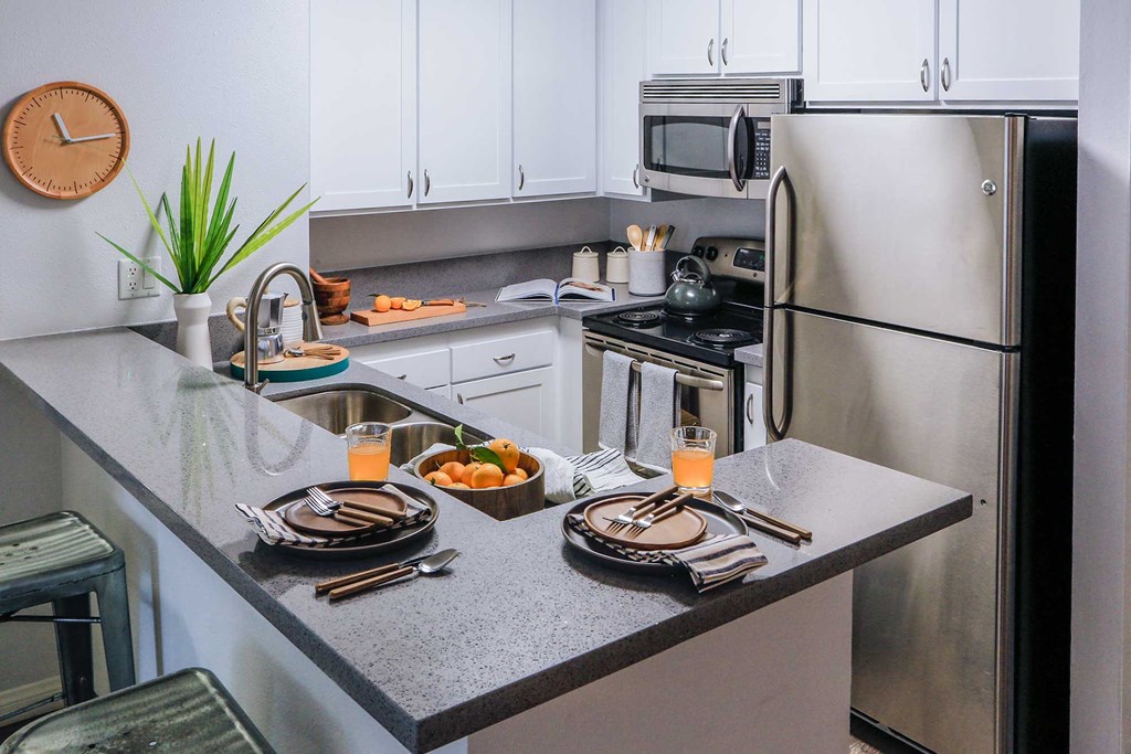 Modern Kitchen with a Breakfast Bar, Energy Efficient Appliances, and Wood Style Flooring