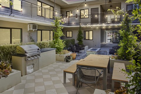 Outdoor grill and dining area at night with string lights