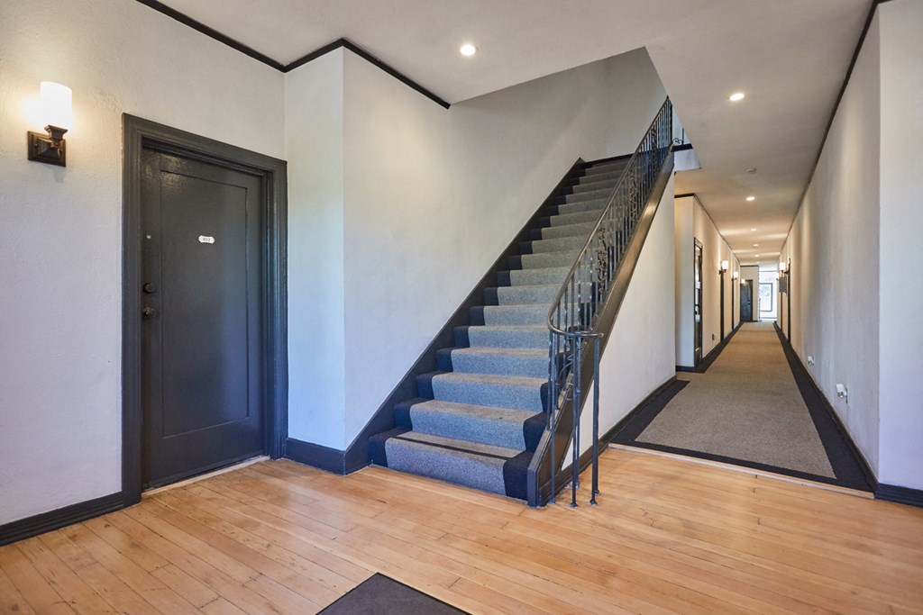 Brightly-lit hallway between units with steps leading up