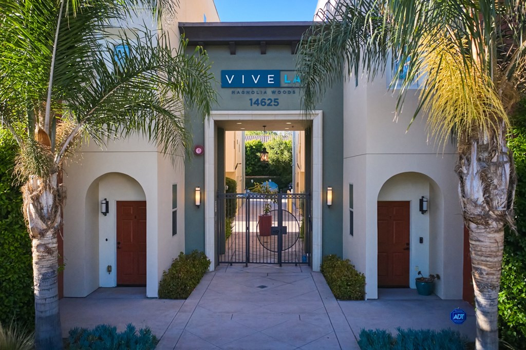 Exterior entrance bracketed by palm trees